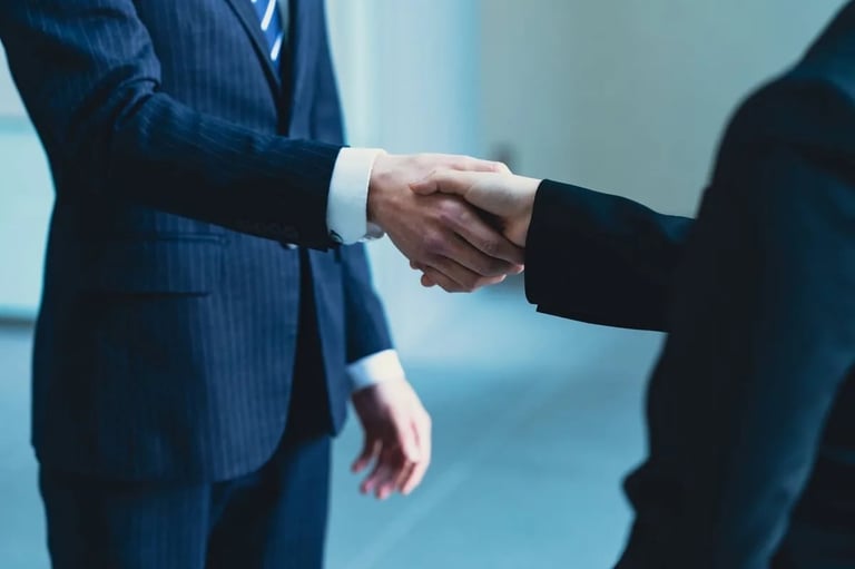 Two businessmen in suits shaking hands in a professional agreement or greeting